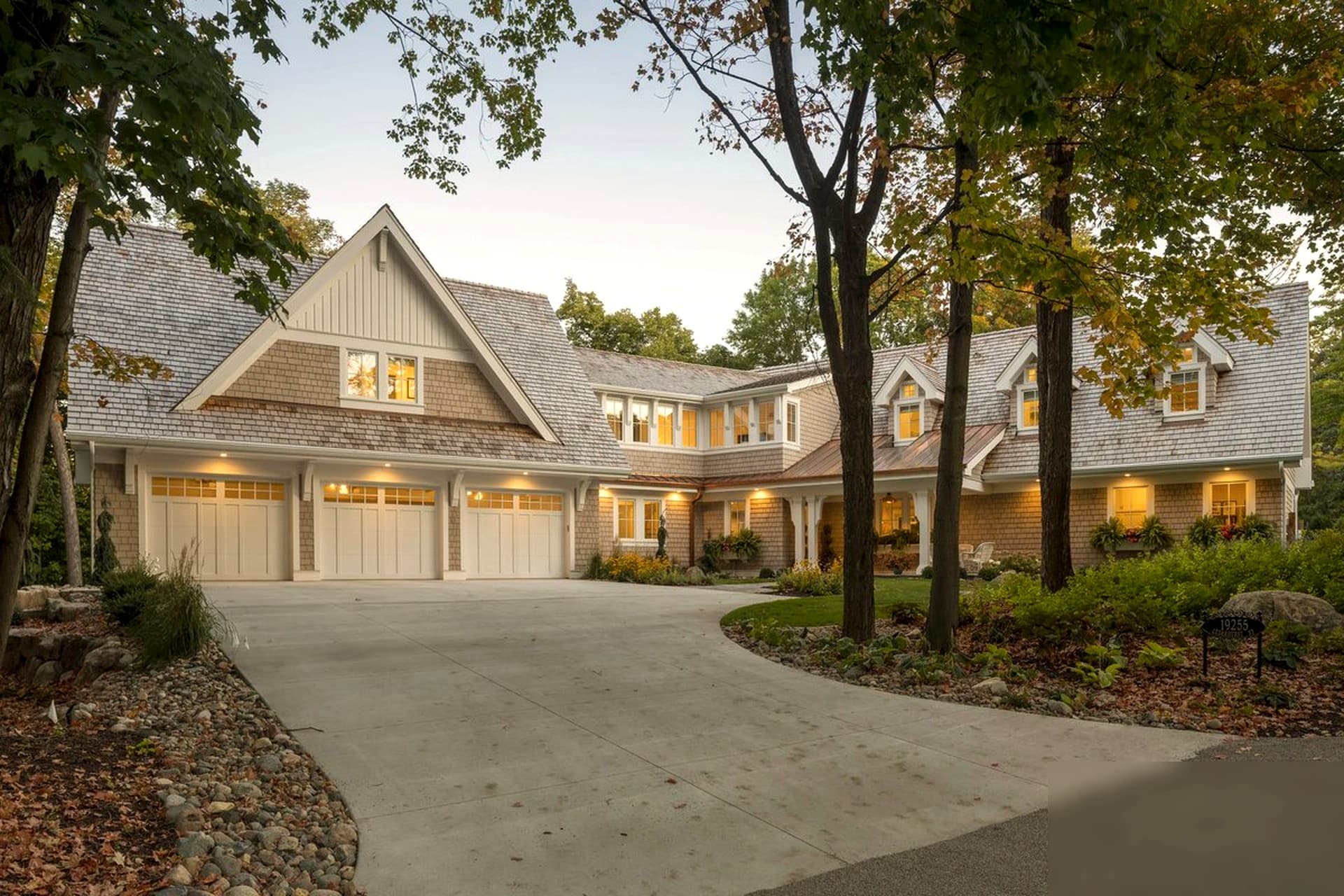 Luxury home exterior at twilight — warm glow from every window