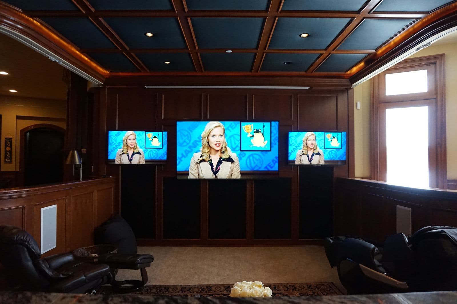 Multi-screen sports viewing room with three TVs and leather recliners