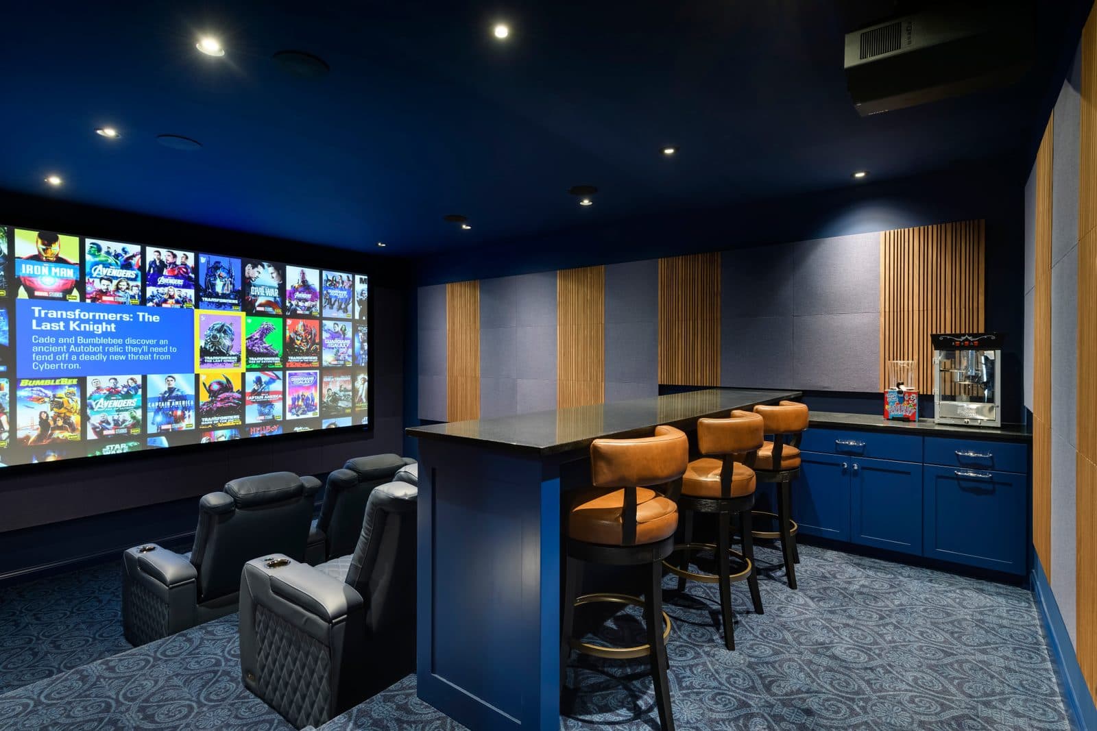 Luxury home theater with Kaleidescape movie server, acoustic panels, and bar seating
