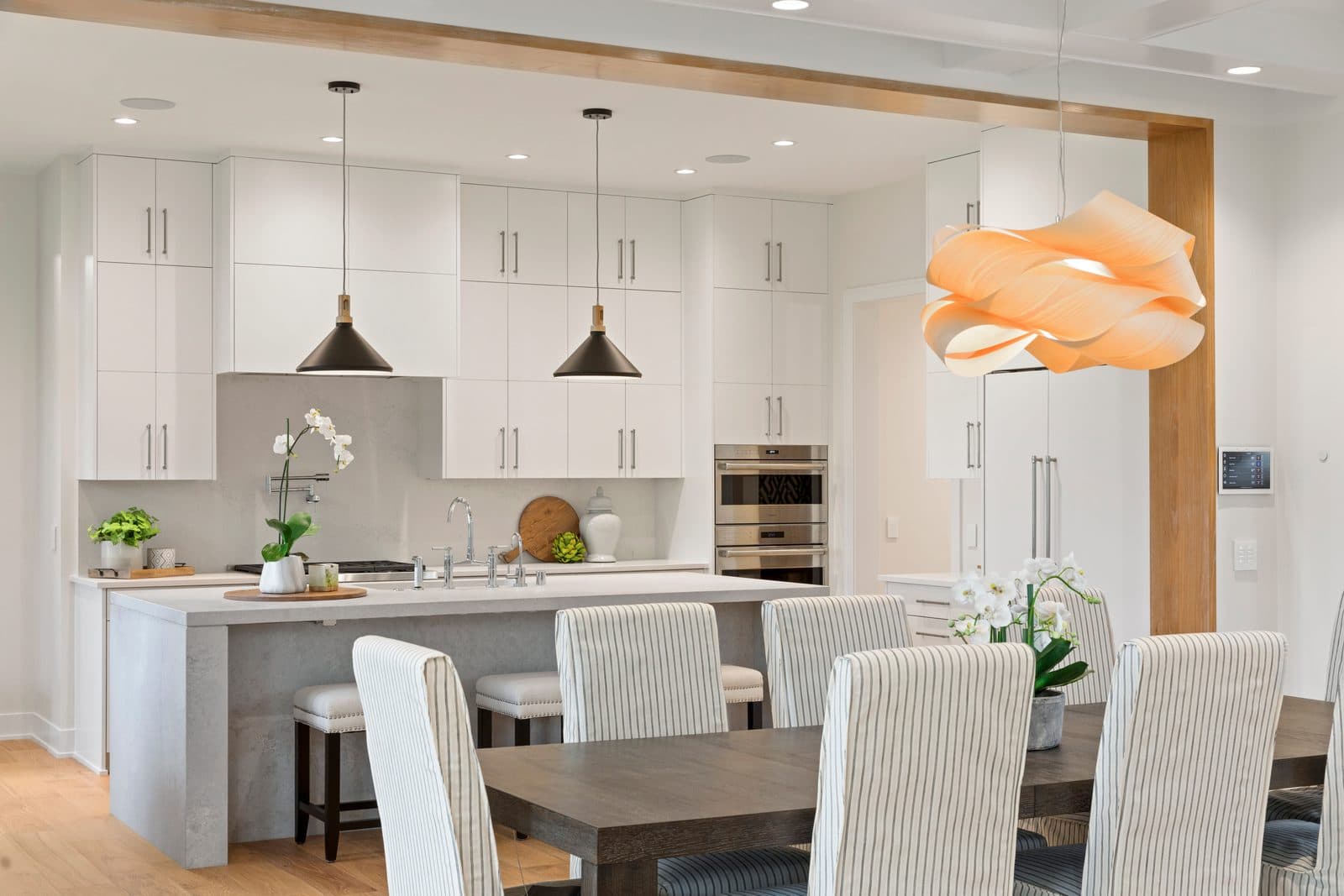 Open kitchen with visible smart home control panel and integrated appliances